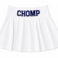 A white pleated cheerleader-style athletic  skirt with the word 'CHOMP' printed across the waistband in dark navy blue block letters, shown on a plain white background. Chomp is a Florida fan phrase. 