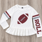 A white long-sleeve t-shirt with a ruffled hem, featuring a crimson football graphic on the chest, crimson and gray stripes on the sleeves, and the word 'ROLL' printed vertically on one sleeve, laid flat on a gray wood background. This is a SPF t-shirt for girls for gameday in Alabama. 