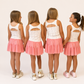 Girls in Two-Piece Bow and Pink  Skirt sets with ink skirts overlays and bow pinted detail 