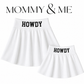 Two white pleated skirts with black 'HOWDY' text on the waistbands, shown on a white background with 'MOMMY & ME' text above. One skirt is larger and one is smaller, suggesting a matching set.